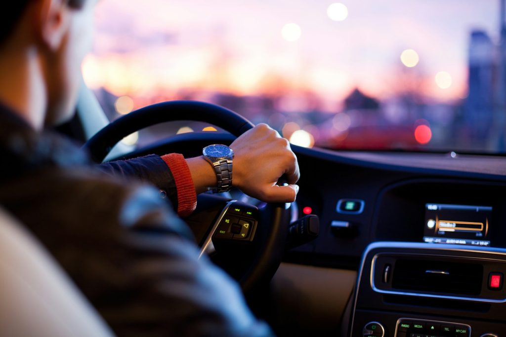 Hands on a car steering wheel while driving representing road traffic accidents